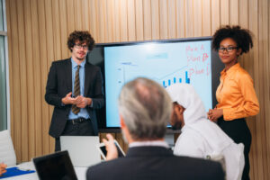 Two business professionals give a presentation to their coworkers