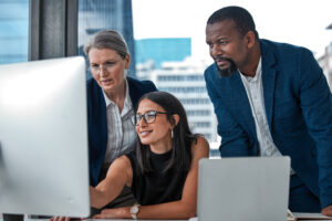 IT consultants helping woman on computer in office